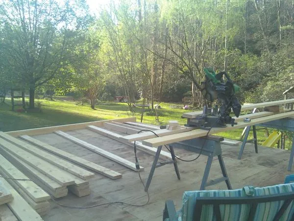 Miter saw and framing lumber on a deck under construction in Deerfield